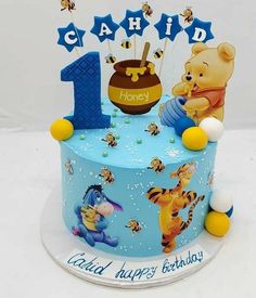 a blue winnie the pooh birthday cake with honey bears and stars on it,