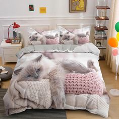 a bed with two cats on it and some balloons in the room behind them,