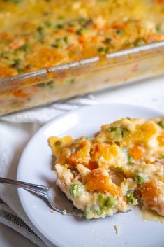 a white plate topped with a casserole covered in broccoli and cheese