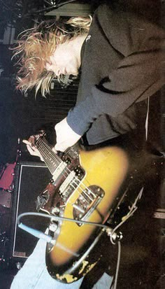 a man playing an electric guitar on stage