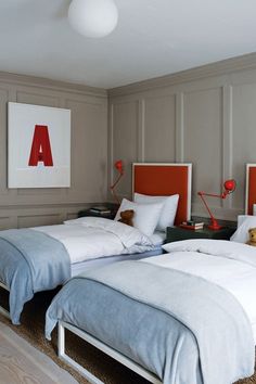 two beds in a room with red headboards