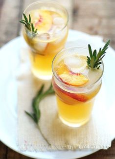 two glasses filled with drinks sitting on top of a white plate