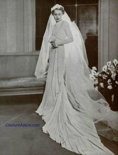 an old black and white photo of a woman in a wedding dress wearing a veil