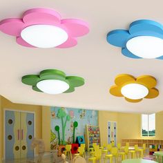 the children's room is decorated in bright colors and has round ceiling lights with flowers on them