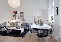 a living room filled with lots of furniture and decor on top of a hard wood floor