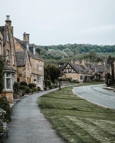 an empty street lined with houses in the middle of a rural town on a cloudy day