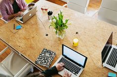 two people sitting at a table with laptops