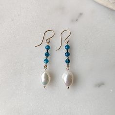 Like the clear blue waters of the ocean get lost in these Blue Apatite and Freshwater Pearl dangle earrings. The stunning faceted Blue Apatite gemstones have the most captivating transparent blue color to them. They are paired with organically shaped freshwater pearls to give you that tropical/coastal vibe. Both the Blue Apatite and Freshwater Pearls are superior AAA grade gemstones (the best you can get!) That is why the Blue Apatite has that dreamy transparent deep blue color, and the pearls h Clear Blue Water, Pearl Dangle Earrings, Blue Apatite, Pearl Earrings Dangle, Pearl Drop, Blue Water, Earring Necklace, Deep Blue, The Ocean