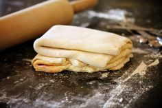 some food that is on top of a table with utensils and a rolling pin