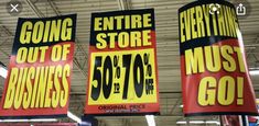 three large signs hanging from the ceiling in a store with prices on them and other items for sale