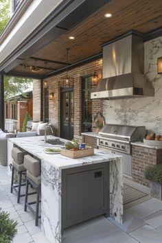 an outdoor kitchen with marble counter tops and bar stools