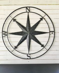 a metal compass hanging on the side of a wall