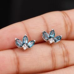 Product Details Gracefully designed, these Floral Stud Earrings are adorned with Marquise Cut London Blue Topaz gemstones and round shape Moissanite to make for a charming and trendy choice for special evenings. These 3 Petal Earrings are a perfect addition to your jewelry collection. Product Information SKU SHP-EARRINGS062017086 Length 8.4 mm Width 11.8 mm Weight 2.02 gm (Approximate) LONDON BLUE TOPAZ INFORMATION No.of Stones 6 Pieces Total Weight 1.74 Carat (Approximate) Dimension(approx) Mar Petal Earrings, Minimal Earrings, Floral Studs, Topaz Earrings, London Blue Topaz, Topaz Gemstone, Marquise Cut, London Blue, Round Shape