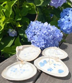 three blue hydrangeas sitting on top of a wooden table