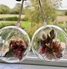 two clear glass vases with flowers in them