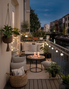 the balcony is decorated with lights and furniture for outdoor entertaining purposes, as well as potted plants