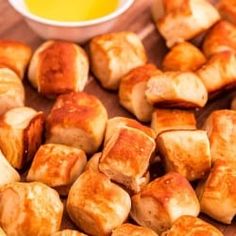 some kind of food that is sitting on a wooden table with dipping sauce in the background