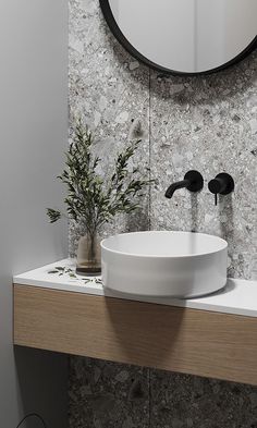 a white sink sitting on top of a wooden counter next to a wall mounted mirror