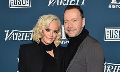 a man standing next to a woman on a red carpet