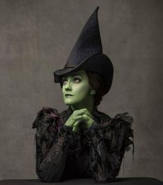 a woman with green makeup and black dress