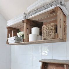 a bathroom shelf with towels and baskets on it