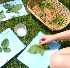 someone is cutting up leaves with scissors on the ground next to some papers and a basket