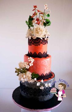 a three tiered cake decorated with flowers and lace