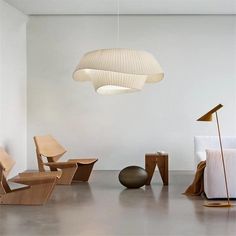 a room with chairs, tables and lamps on the floor next to each other in front of a white wall