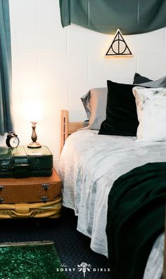 a bed with two suitcases on top of it and a lamp next to it