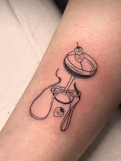 a tattoo on the leg of a woman with a cake and cupcake in it