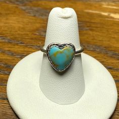 Authentic Turquoise Heart Silver Ring. Gorgeous And Unique Statement Piece. Sterling Silver Band (Unstamped), Turquoise With Natural Yellow/Brown Lining In A Heart Shape (925 Stamped), Sweet Braided Detailing Around The Heart, Scalloped Edging Around The Turquoise, The Stone Measures 10mm, And Made In Montana. Hard To Find Item! Size 6.5. Last Three Pictures Are The Actual Ring Being Sold. Turquoise Gemstone Heart Ring For Anniversary, Heart-shaped Turquoise Ring For Anniversary, Nickel Free Heart Shaped Ring, Handmade Blue Heart Shaped Ring, Handmade Blue Heart Ring, Heart-shaped Turquoise Blue Ring For Gift, Heart-shaped Turquoise Ring As Gift, Heart-shaped Blue Turquoise Ring For Gift, Heart-shaped Blue Turquoise Ring Gift