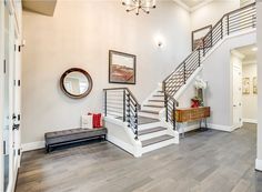 a staircase leading up to the second floor in a home with white walls and wood floors