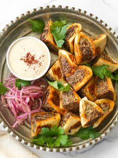 a bowl filled with food and garnished with cilantro, red onion, and pita bread