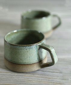 two green cups sitting on top of a wooden table