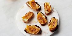 toasted bread topped with orange slices on a white plate next to an orange slice