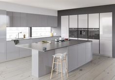 a large kitchen with an island in the middle and two stools next to it