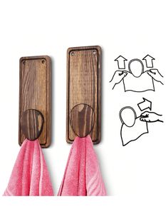 two wooden hooks with pink towels hanging from them