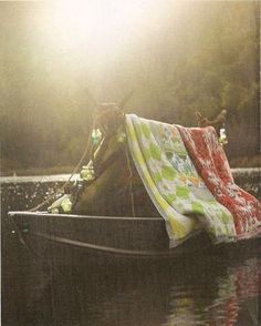 a person sitting in a boat with a blanket on it