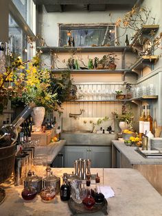 a kitchen filled with lots of bottles and glasses on top of a counter next to a sink