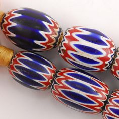 four red, white and blue glass beads with wood spools on them sitting next to each other