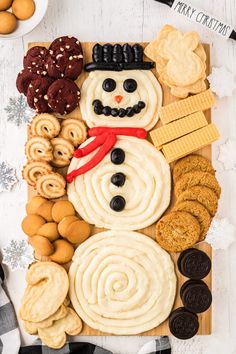 a snowman made out of cookies and crackers on a cutting board with the words merry christmas written across it