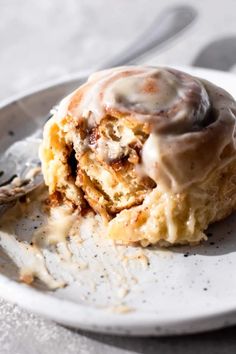 a white plate topped with a pastry covered in icing