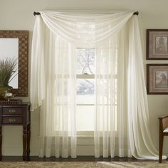 a living room with a window covered in sheer curtains