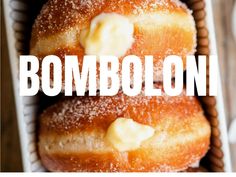 two donuts covered in powdered sugar sit in a basket with the words bomboloni on it