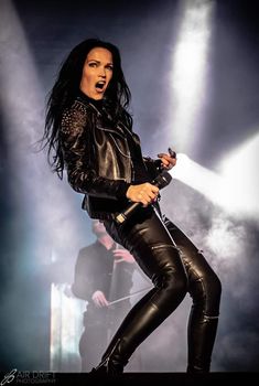 a woman in black leather outfit on stage