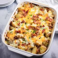 a casserole dish with potatoes, bacon and cheese in it on a table