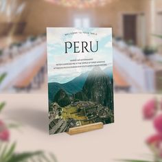 the book peru is sitting on top of a table with flowers in front of it