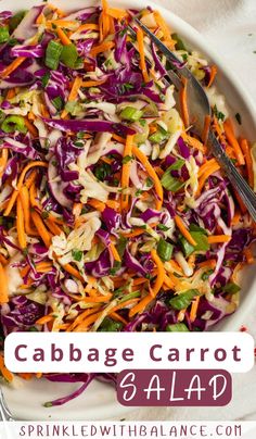 cabbage carrot salad in a white bowl with a serving spoon and fork on the side