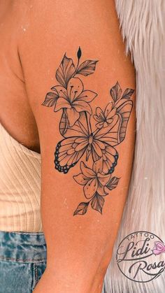 a woman with a tattoo on her arm and flowers in the middle of her arm