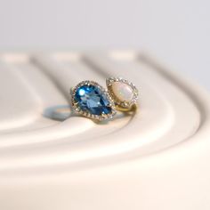 Description This beautiful two stones ring is crafted in 14-karat yellow gold and features pave diamonds. It is a perfect gift either for yourself or someone you love. 14K Yellow Gold Gemstone: Blue Topaz & Opal Cut: Pear cut Weight: 3.65 ct of blue topaz, 0.60 ct of peridot, 0.41 ctw of diamonds Diamond color: G-H Diamond clarity: SI1-SI2 Size 7 in stock and re size available Topaz And Opal Ring, Opal And Topaz Ring, Opal And Blue Topaz Ring, Unique Gemstone Rings, Yellow Topaz Ring, Topaz Engagement Ring, London Blue Topaz Ring, Lancaster Pa, Unique Gemstones